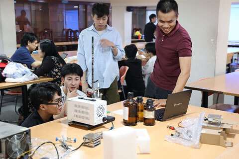 初めての実験に苦戦するIUHの学生に対して英語で説明する本学学生(電気化学による金属葉の作製)