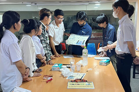 自作の資料を用いて説明する本学学生(燃料電池の実演)