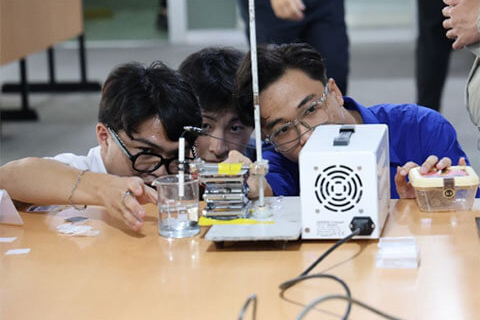 真剣に実験に取り組むベトナムの高校生(電気化学による金属葉の作製)